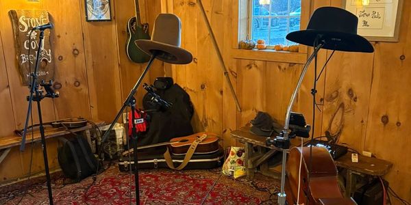 Silver Stringer Slingers' cowboy hats hanging on mic stands